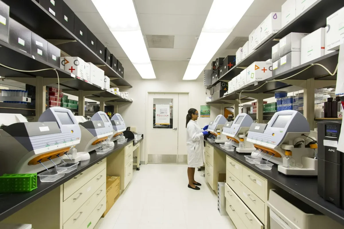 Interior de un laboratorio con equipos y una científica